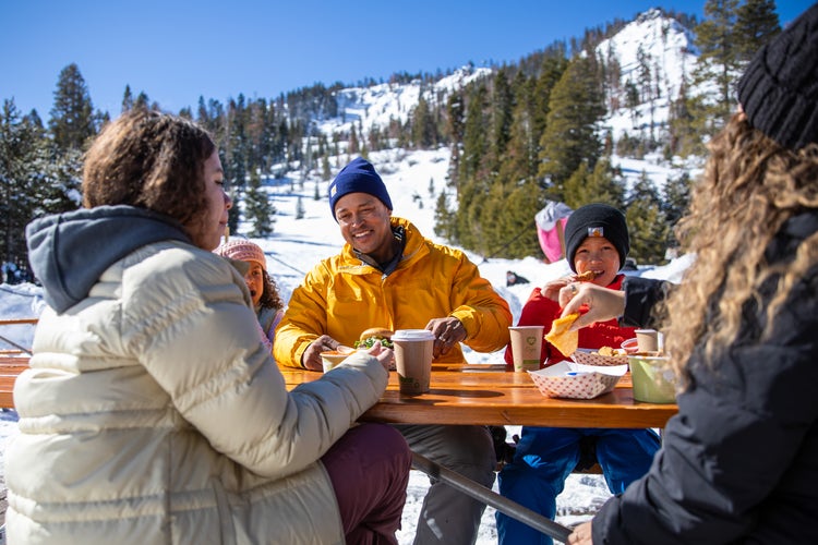 Family enjoying hot drinks at snowy picnic