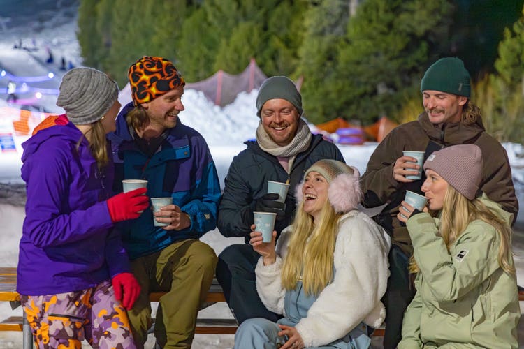 Friends enjoying hot drinks at snowy resort