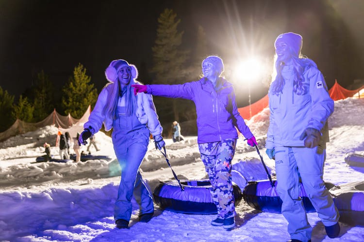 Friends tubing together at night in winter